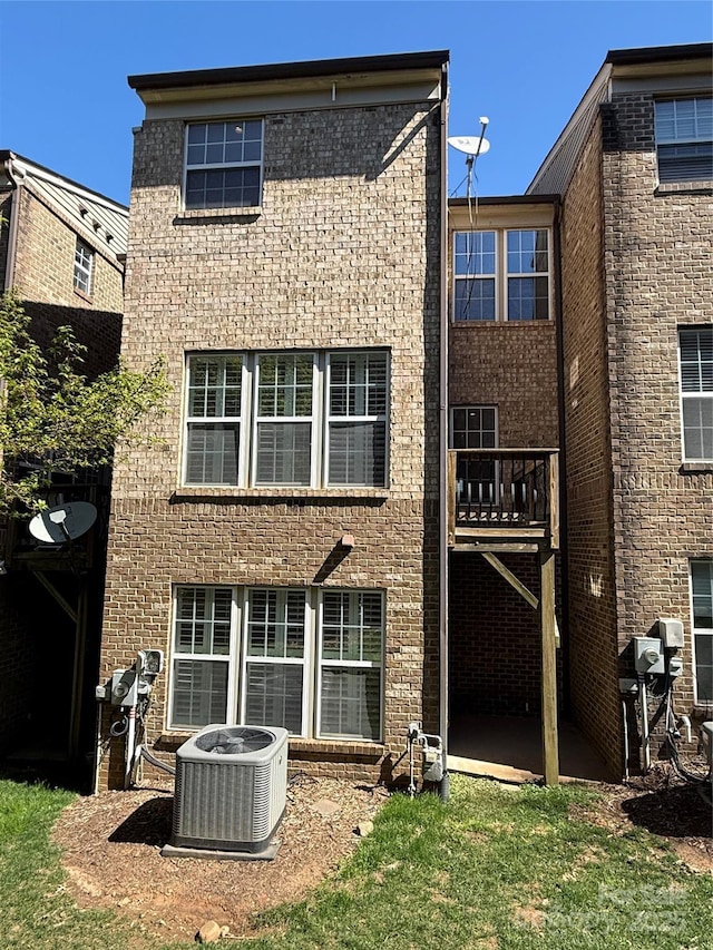243 Lincoln St, Charlotte, NC 28203 - back of property featuring central AC unit, brick siding, and a patio