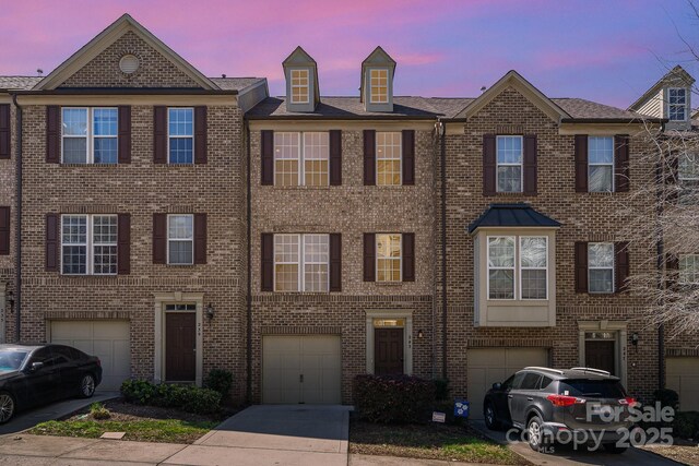 243 Lincoln St, Charlotte, NC 28203 - townhome / multi-family property with a garage, driveway, and brick siding