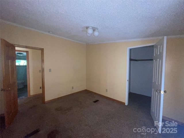 3103 Blue Ridge Dr, Shelby, NC 28150 - unfurnished bedroom with a textured ceiling, ornamental molding, baseboards, carpet floors, and a walk in closet