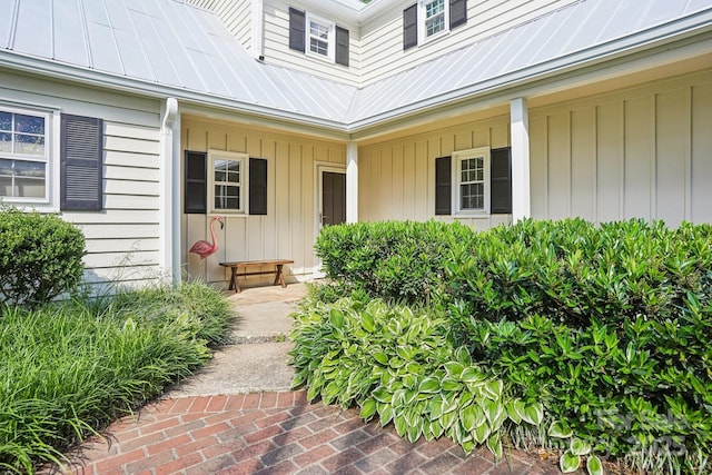 doorway to property featuring metal roof and a porch