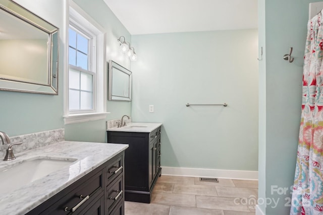 bathroom with two vanities and baseboards