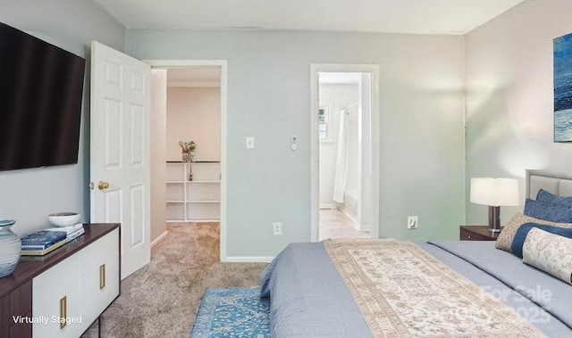 bedroom featuring light colored carpet, baseboards, and ensuite bathroom