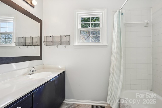 bathroom with vanity, shower / tub combo, and baseboards