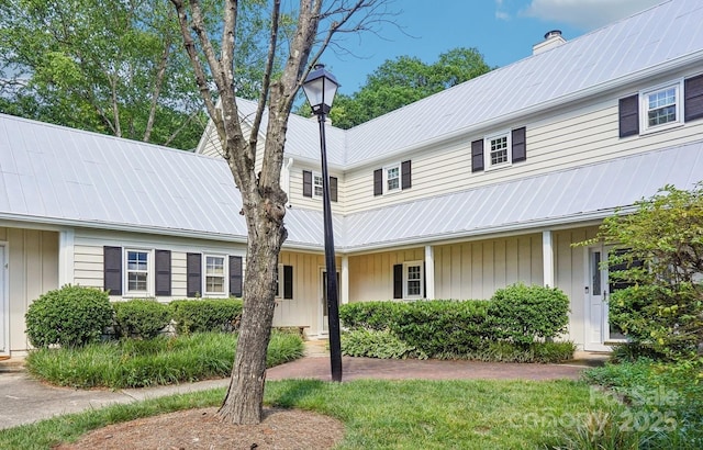 view of front of home featuring metal roof and a chimney