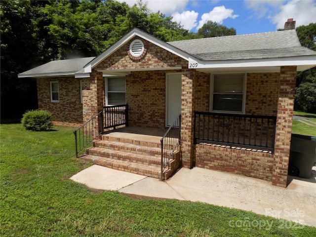 209 Barber Rd, Gastonia, NC 28056 - ranch-style home with a chimney, a front lawn, brick siding, a porch, and roof with shingles