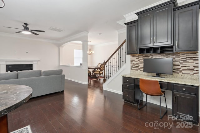 home office with ornamental molding, ceiling fan, baseboards, dark wood finished floors, and a chandelier