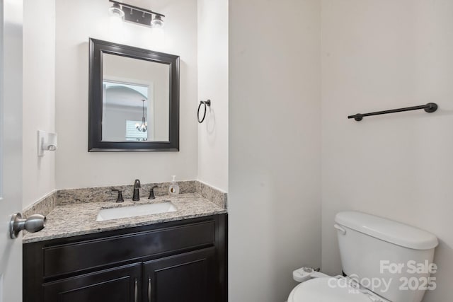 half bathroom with toilet and vanity