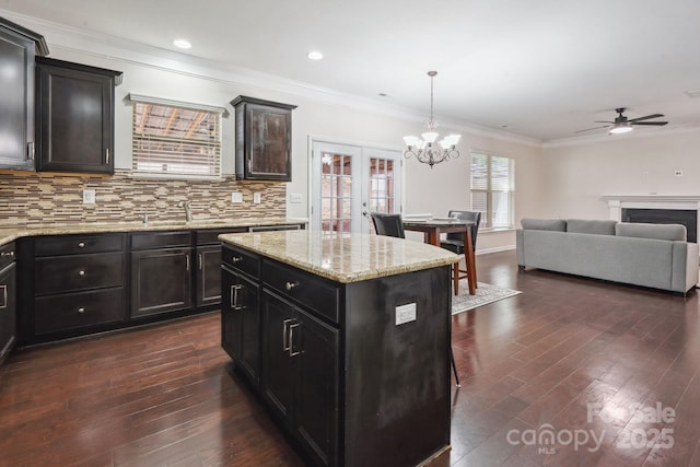 kitchen featuring a chandelier, crown molding, dark wood-style floors, tasteful backsplash, and a ceiling fan