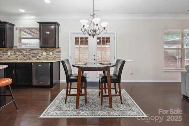 dining space featuring dark wood-style flooring, a chandelier, ornamental molding, baseboards, and recessed lighting