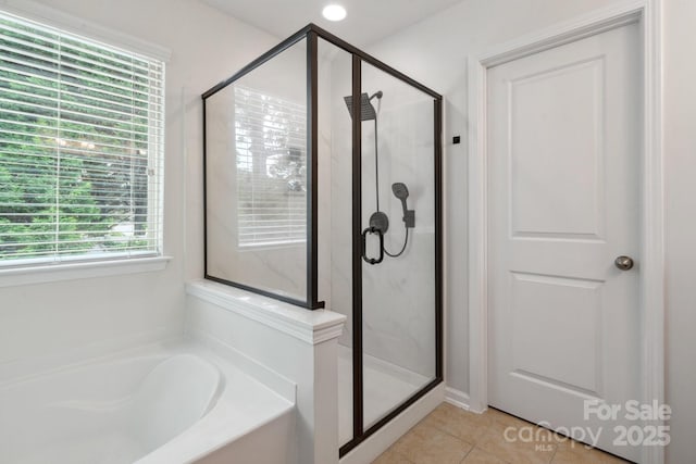 full bathroom with tile patterned flooring, a bath, and a stall shower