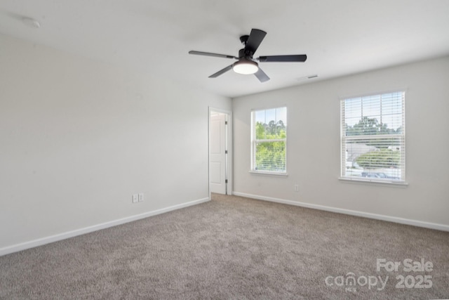 carpeted empty room with baseboards and a ceiling fan