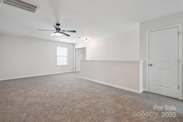 empty room featuring ceiling fan, carpet, and baseboards