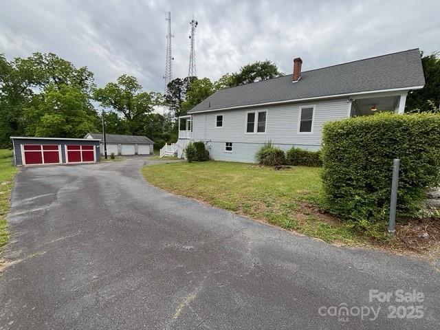 103 Duke St, Great Falls, SC 29055 - view of side of home featuring a chimney, a yard, a detached garage, and an outbuilding