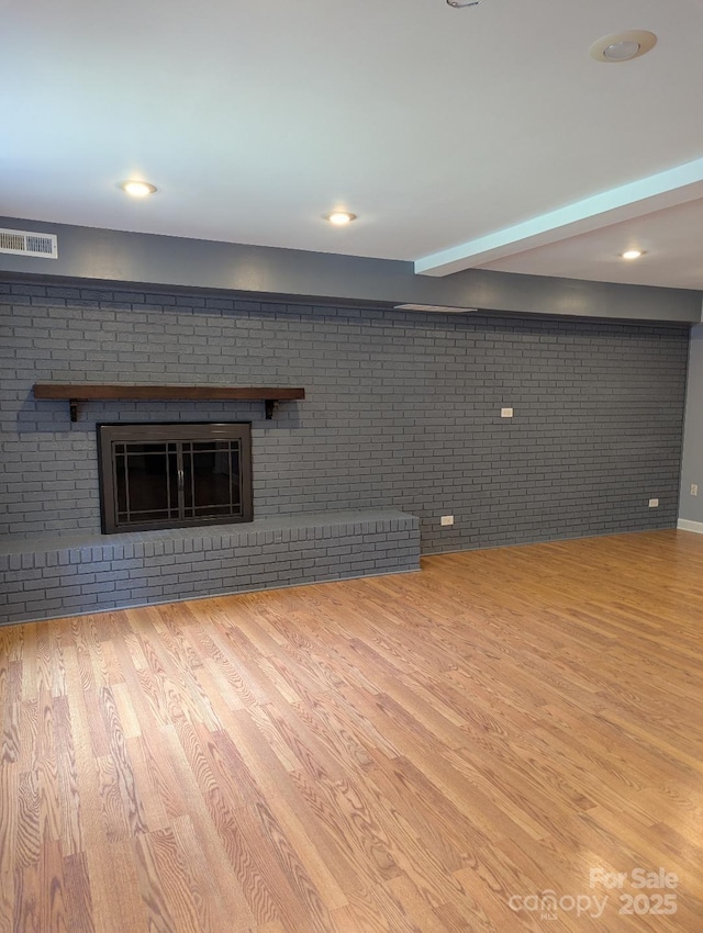 715 Gentry Pl, Charlotte, NC 28210 - unfurnished living room with brick wall, wood finished floors, recessed lighting, a fireplace, and beam ceiling