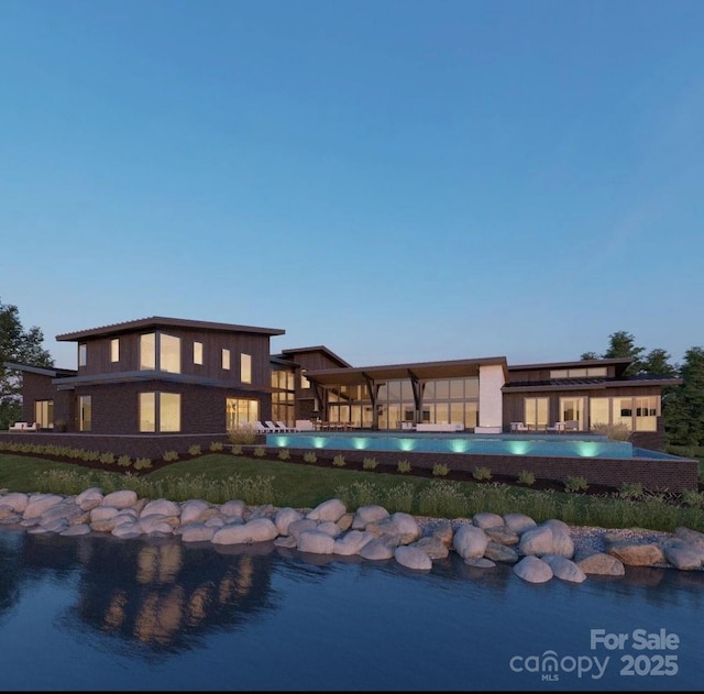 pool at dusk featuring a yard and an outdoor pool