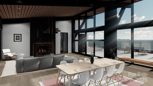 living area with wood finished floors, a lit fireplace, a water view, and wooden ceiling