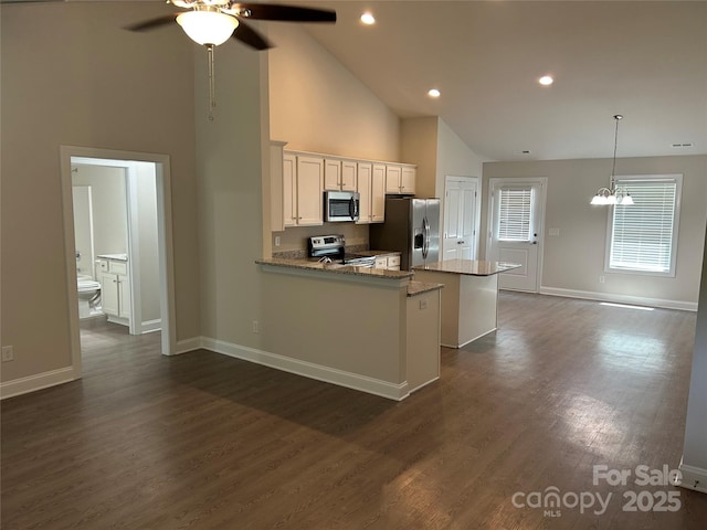 kitchen featuring appliances with stainless steel finishes, high vaulted ceiling, ceiling fan, a center island, and white cabinetry