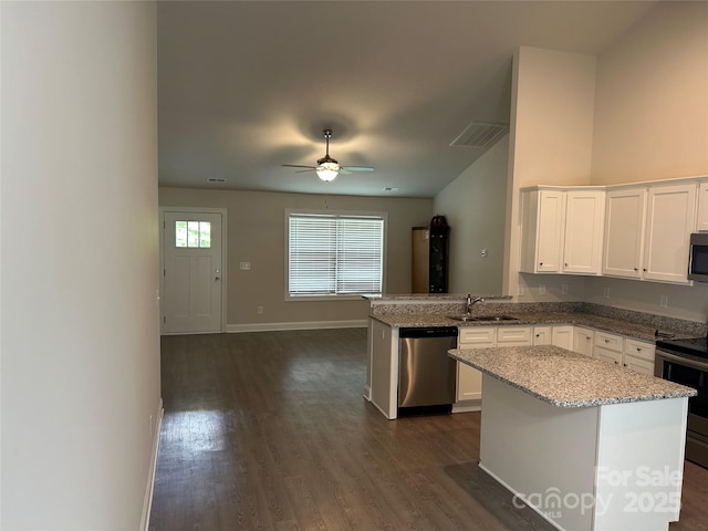 kitchen featuring appliances with stainless steel finishes, dark wood-type flooring, white cabinetry, and a ceiling fan