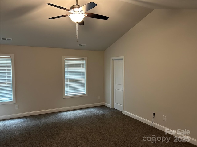 unfurnished room with lofted ceiling, dark carpet, ceiling fan, and baseboards