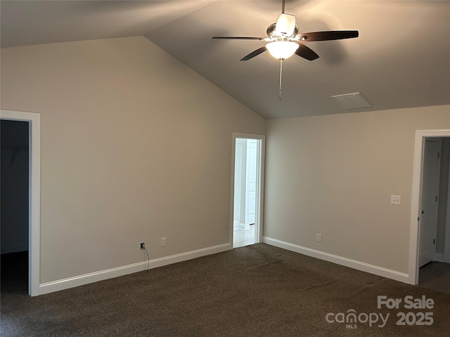unfurnished bedroom with lofted ceiling, dark carpet, baseboards, and ceiling fan