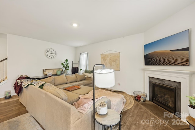3985 Village Blvd NW, Conover, NC 28613 - living room featuring wood finished floors, a glass covered fireplace, stairs, baseboards, and recessed lighting