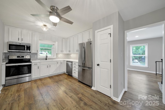 8514 Timber Crest Cir, Charlotte, NC 28226 - kitchen with appliances with stainless steel finishes, a sink, dark wood-style flooring, light countertops, and tasteful backsplash