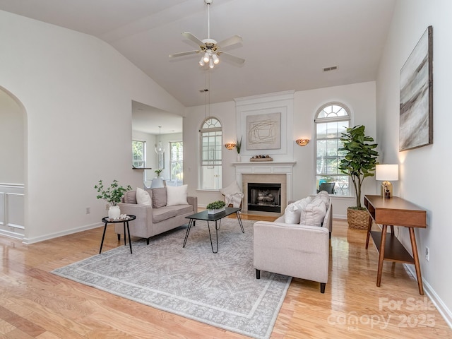 3066 Orion Dr, Fort Mill, SC 29707 - living area with light wood-style floors, vaulted ceiling, a ceiling fan, arched walkways, and a fireplace with flush hearth
