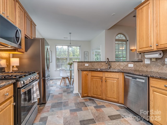 3066 Orion Dr, Fort Mill, SC 29707 - kitchen featuring appliances with stainless steel finishes, a sink, a peninsula, dark stone finish flooring, and backsplash