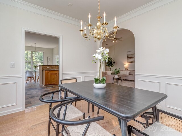 3066 Orion Dr, Fort Mill, SC 29707 - dining room featuring a decorative wall, ornamental molding, wainscoting, a chandelier, and arched walkways