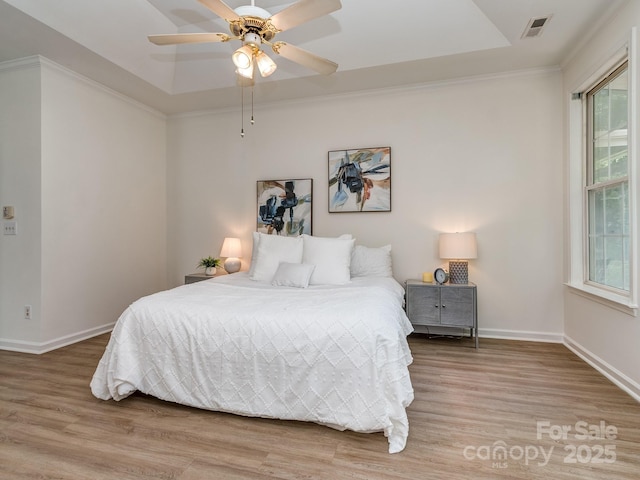 3066 Orion Dr, Fort Mill, SC 29707 - bedroom featuring light wood-type flooring, baseboards, a raised ceiling, a ceiling fan, and ornamental molding