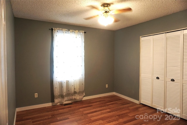 1958 19th Avenue Dr NE Unit 8, Hickory, NC 28601 - unfurnished bedroom with dark wood-style flooring, a closet, a textured ceiling, baseboards, and a ceiling fan
