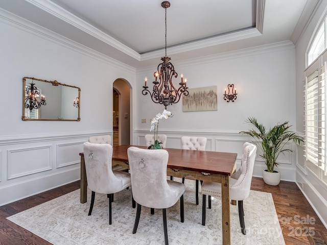 1404 Lookout Cir, Waxhaw, NC 28173 - dining space featuring a chandelier, arched walkways, ornamental molding, a decorative wall, and dark wood finished floors