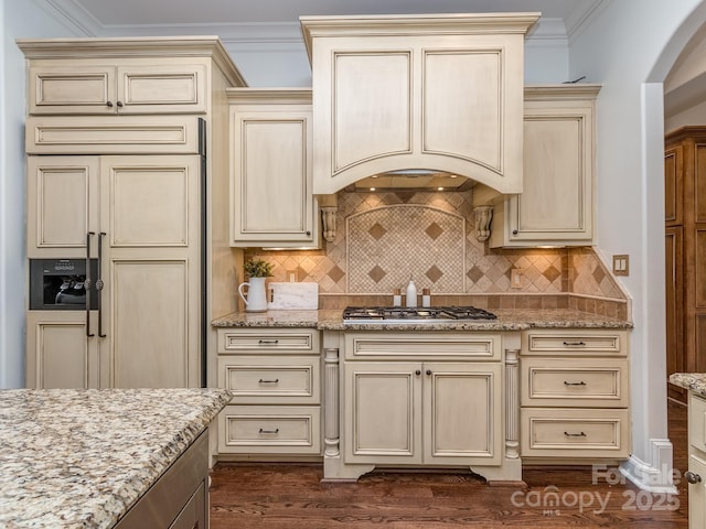 1404 Lookout Cir, Waxhaw, NC 28173 - kitchen with cream cabinets, paneled fridge, arched walkways, stainless steel gas stovetop, and light stone countertops