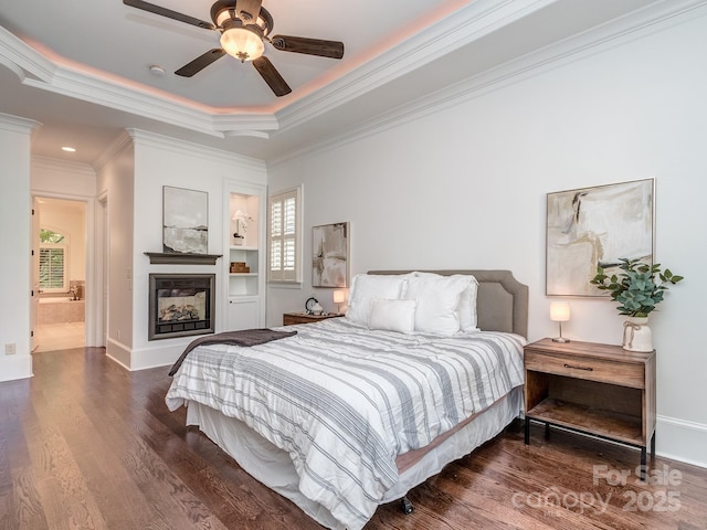 1404 Lookout Cir, Waxhaw, NC 28173 - bedroom with wood finished floors, a tray ceiling, a multi sided fireplace, ornamental molding, and baseboards