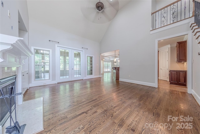 4113 Hoffmeister Dr, Waxhaw, NC 28173 - unfurnished living room featuring ceiling fan, high vaulted ceiling, a fireplace, wood finished floors, and baseboards
