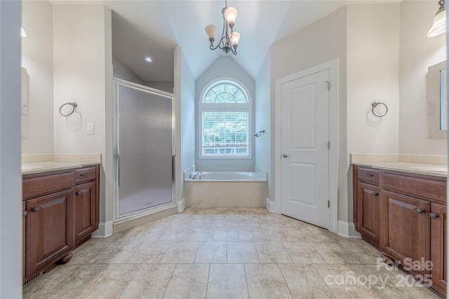 4113 Hoffmeister Dr, Waxhaw, NC 28173 - full bathroom featuring two vanities, vaulted ceiling, a shower stall, a chandelier, and a garden tub