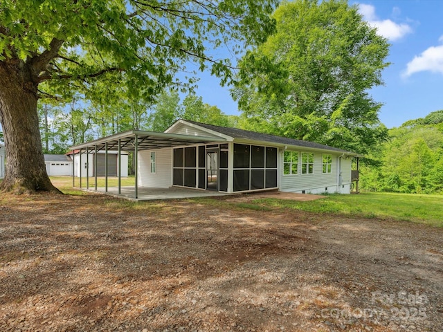 back of property with a sunroom, driveway, and a yard