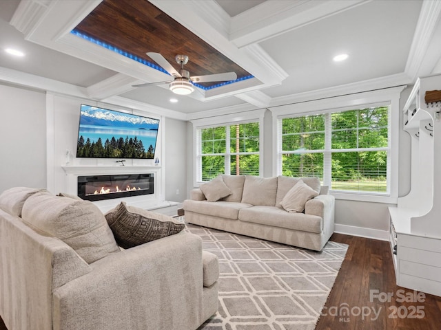 living room with a ceiling fan, crown molding, a glass covered fireplace, baseboards, and wood finished floors