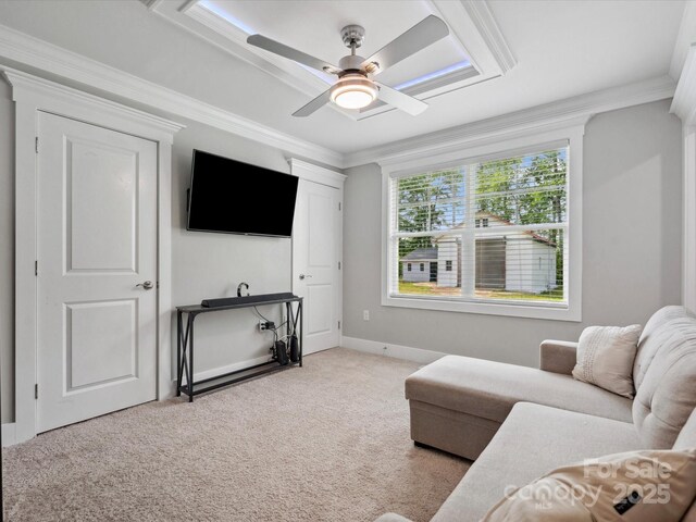 carpeted living room with a ceiling fan and crown molding