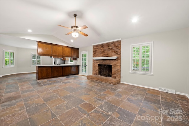 kitchen featuring open floor plan, a ceiling fan, baseboards, a peninsula, and light countertops