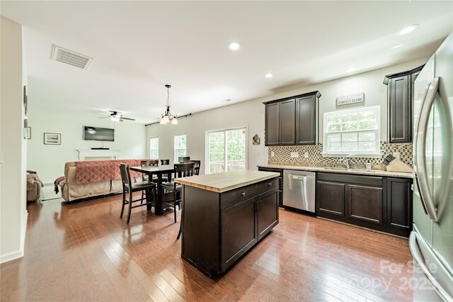7650 W Berkeley Rd, Denver, NC 28037 - kitchen featuring appliances with stainless steel finishes, open floor plan, tasteful backsplash, hardwood / wood-style floors, and wood counters