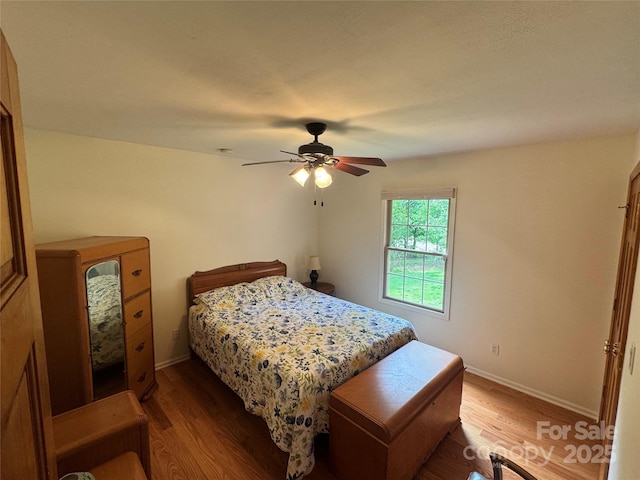 bedroom featuring wood finished floors, ceiling fan, and baseboards
