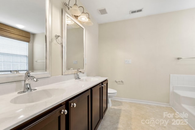 12824 Harvest Time Ct, Charlotte, NC 28278 - bathroom with a garden tub, baseboards, double vanity, toilet, and tile patterned flooring