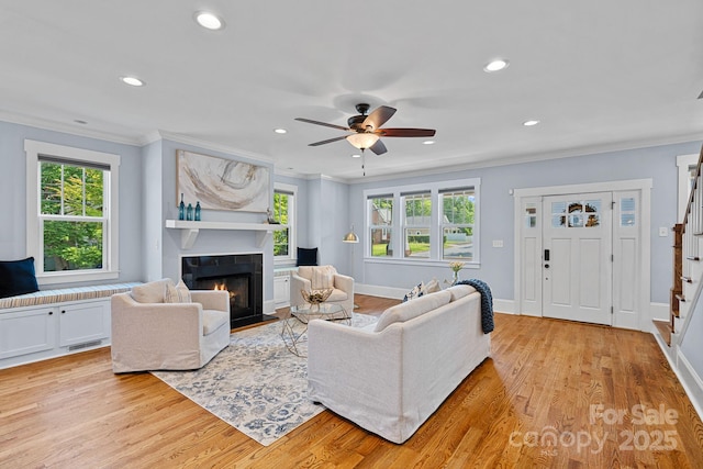 331 Solomon St, Charlotte, NC 28216 - living room featuring stairs, a lit fireplace, ornamental molding, light wood-style floors, and recessed lighting