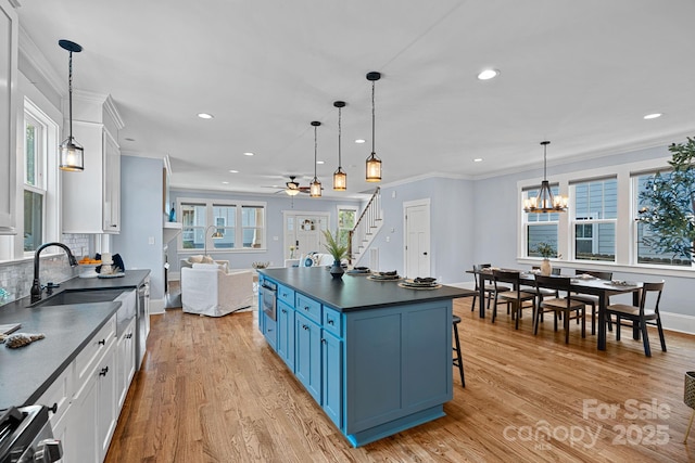 331 Solomon St, Charlotte, NC 28216 - kitchen featuring dark countertops, blue cabinetry, white cabinetry, a sink, and recessed lighting