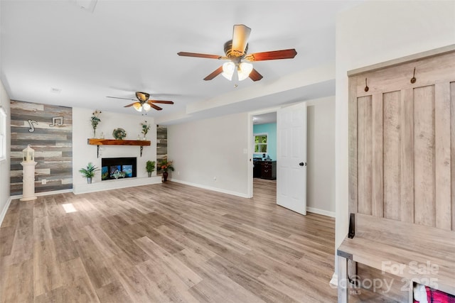 1822 N New Hope Rd, Gastonia, NC 28054 - unfurnished living room with ceiling fan, baseboards, a large fireplace, and light wood-type flooring