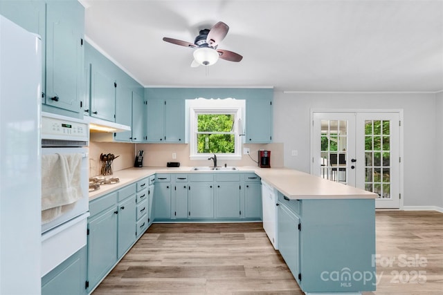 1822 N New Hope Rd, Gastonia, NC 28054 - kitchen with a peninsula, blue cabinets, white oven, a sink, and french doors