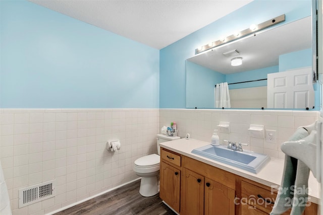 1822 N New Hope Rd, Gastonia, NC 28054 - full bath with tile walls, wood finished floors, curtained shower, toilet, and vanity