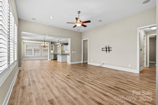 7362 Overjoyed Xing, Charlotte, NC 28215 - unfurnished living room featuring a chandelier, light wood-type flooring, a ceiling fan, and baseboards