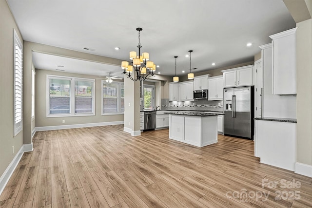 7362 Overjoyed Xing, Charlotte, NC 28215 - kitchen featuring appliances with stainless steel finishes, open floor plan, a chandelier, dark countertops, and light wood-type flooring